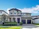 Stunning two-story home with stone accents, a well-manicured lawn, and an attached two-car garage at 12880 Westside Village Loop, Windermere, FL 34786