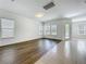 Living room boasting hardwood flooring, white walls, large windows and rear glass door accessing outside at 12880 Westside Village Loop, Windermere, FL 34786