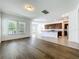 Open floor plan with hardwood in the living room transitioning into the tiled kitchen with granite counters and a bar at 12880 Westside Village Loop, Windermere, FL 34786