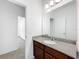 Bathroom featuring granite countertop, dark wood cabinets, white sink, and an oversized mirror at 12971 Westside Village Loop, Windermere, FL 34786