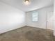 Bedroom with neutral carpet, white walls, one window with blinds, and a door at 12971 Westside Village Loop, Windermere, FL 34786