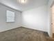 Bedroom with neutral carpet, white walls, one window with blinds, and a door at 12971 Westside Village Loop, Windermere, FL 34786