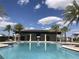 Community pool with covered area, palm trees and comfortable lounging area at 12971 Westside Village Loop, Windermere, FL 34786