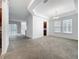 Spacious carpeted living room with tray ceiling, natural light, and kitchen access at 12971 Westside Village Loop, Windermere, FL 34786