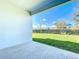 Covered patio with view of backyard, lush lawn, and neighborhood at 12971 Westside Village Loop, Windermere, FL 34786