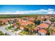 Expansive aerial view of a residential neighborhood with orange tile roofs and lush landscaping on a sunny day at 131 Stella Pass, Davenport, FL 33837