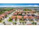 Aerial view of a residential neighborhood featuring orange tile roofs and tree-lined streets at 131 Stella Pass, Davenport, FL 33837