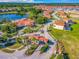 Aerial view of the community entrance and amenities with lush landscaping and orange tile roofs at 131 Stella Pass, Davenport, FL 33837