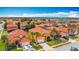 Expansive aerial view of a vibrant neighborhood with homes featuring red tile roofs and well-maintained landscaping at 131 Stella Pass, Davenport, FL 33837