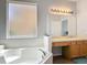 Relaxing bathroom offers a corner soaking tub, vanity area, and a large, frosted window at 131 Stella Pass, Davenport, FL 33837