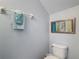 Cozy powder room featuring decorative art, a toilet, and fresh towels at 131 Stella Pass, Davenport, FL 33837