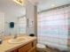 Full bath with a tan vanity, patterned shower curtain and matching decor at 131 Stella Pass, Davenport, FL 33837