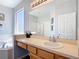 Bright bathroom features a vanity with storage and separate tub and shower areas at 131 Stella Pass, Davenport, FL 33837