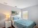 Comfortable bedroom with a queen bed, white leather headboard, a lamp, and natural light from the window at 131 Stella Pass, Davenport, FL 33837