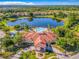 Aerial view of the community center and pool with well-manicured landscaping and a lake at 131 Stella Pass, Davenport, FL 33837
