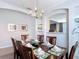 Formal dining room featuring a wooden table, elegant chandelier, built-in shelving, and plenty of natural light at 131 Stella Pass, Davenport, FL 33837