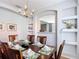 Formal dining room with a wooden table, chandelier, built-in shelving, and a peek into the adjacent room at 131 Stella Pass, Davenport, FL 33837