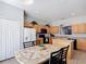 Eat-in kitchen features a tile backsplash, black appliances, and ample cabinet space at 131 Stella Pass, Davenport, FL 33837