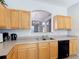 Kitchen featuring wooden cabinets, tile floors, and a stainless steel sink at 131 Stella Pass, Davenport, FL 33837