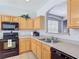 Well-lit kitchen featuring wood cabinets, modern appliances, and a convenient double sink at 131 Stella Pass, Davenport, FL 33837