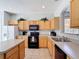 Spacious kitchen with wooden cabinets, stainless-steel appliances, and ample counter space at 131 Stella Pass, Davenport, FL 33837