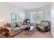 Inviting living room with neutral tones, comfortable seating, a large window, and cozy decor at 131 Stella Pass, Davenport, FL 33837