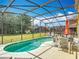 Inviting screened-in pool surrounded by lush greenery, offering a tranquil retreat and outdoor dining space at 131 Stella Pass, Davenport, FL 33837