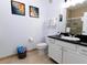 Well-lit bathroom with black countertop, white cabinets, and a tiled shower with glass door at 1351 Tuscan Ter # 8408, Davenport, FL 33896