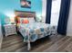 Bright bedroom featuring a queen bed with ocean-themed bedding and modern wood-look flooring at 1351 Tuscan Ter # 8408, Davenport, FL 33896