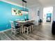 Open concept dining area with modern light fixture, bright blue walls, and seating for six at 1351 Tuscan Ter # 8408, Davenport, FL 33896