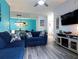 Cozy living room with blue sofas, wood-look flooring, and an open view to the dining area at 1351 Tuscan Ter # 8408, Davenport, FL 33896