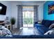 Bright living room with sliding glass doors, patterned curtains, and comfortable blue seating at 1351 Tuscan Ter # 8408, Davenport, FL 33896