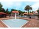 Community splash pad with a fountain, surrounded by lounge seating and lush landscaping at 1351 Tuscan Ter # 8408, Davenport, FL 33896