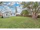 Large backyard offers a green lawn, privacy fence, mature trees, and storage shed for outdoor enjoyment at 1518 Ohio Ave, St Cloud, FL 34769