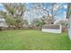 Spacious backyard featuring a green lawn, wooden fence, mature trees, and a convenient storage shed at 1518 Ohio Ave, St Cloud, FL 34769