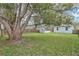 Expansive backyard featuring a lush lawn, mature shade tree, wooden fence, and a storage shed at 1518 Ohio Ave, St Cloud, FL 34769