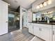 Modern bathroom boasts dual sinks with granite countertops and a glass shower, all illuminated by stylish lighting at 16150 Parkwyn St, Winter Garden, FL 34787