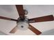 A stylish ceiling fan with wooden blades and an integrated light fixture providing comfort and illumination at 16150 Parkwyn St, Winter Garden, FL 34787