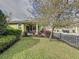 Inviting front yard with a well-maintained lawn, trees, and black metal fence at 16150 Parkwyn St, Winter Garden, FL 34787