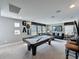 Spacious game room with a pool table, comfortable seating, and stylish decor at 16150 Parkwyn St, Winter Garden, FL 34787