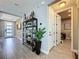 Hallway with a console table and plant, with a view of the entryway and a doorway leading into the laundry room at 16150 Parkwyn St, Winter Garden, FL 34787