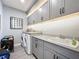 Well-equipped laundry room with gray cabinetry and countertops, plus a washing machine and dryer at 16150 Parkwyn St, Winter Garden, FL 34787