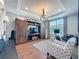 Cozy living room with wooden floors, built-in entertainment center, chandelier, and a comfortable patterned armchair at 16150 Parkwyn St, Winter Garden, FL 34787