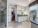 Modern main bathroom featuring a glass-enclosed shower and separate vanities at 16150 Parkwyn St, Winter Garden, FL 34787