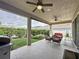 Spacious covered patio featuring ceiling fans, outdoor seating, and a landscaped backyard at 16150 Parkwyn St, Winter Garden, FL 34787