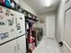 Well-lit laundry room with cabinets, shelving, washer, dryer, and white tiled floor at 168 Bradwick Cir, Debary, FL 32713