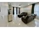 Spacious living room featuring leather furniture, elegant decor, and large windows with modern tile flooring at 168 Bradwick Cir, Debary, FL 32713