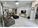 Open-concept living room showcasing a large leather sofa, TV, elegant lighting, and modern tile flooring at 168 Bradwick Cir, Debary, FL 32713