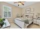 This cozy bedroom features a ceiling fan, natural light, and a charming bed with floral bedding at 19331 Briercrest Trl, Orlando, FL 32833