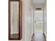 Hallway with wood floors leads to a bathroom featuring a soaking tub beneath a window at 19331 Briercrest Trl, Orlando, FL 32833